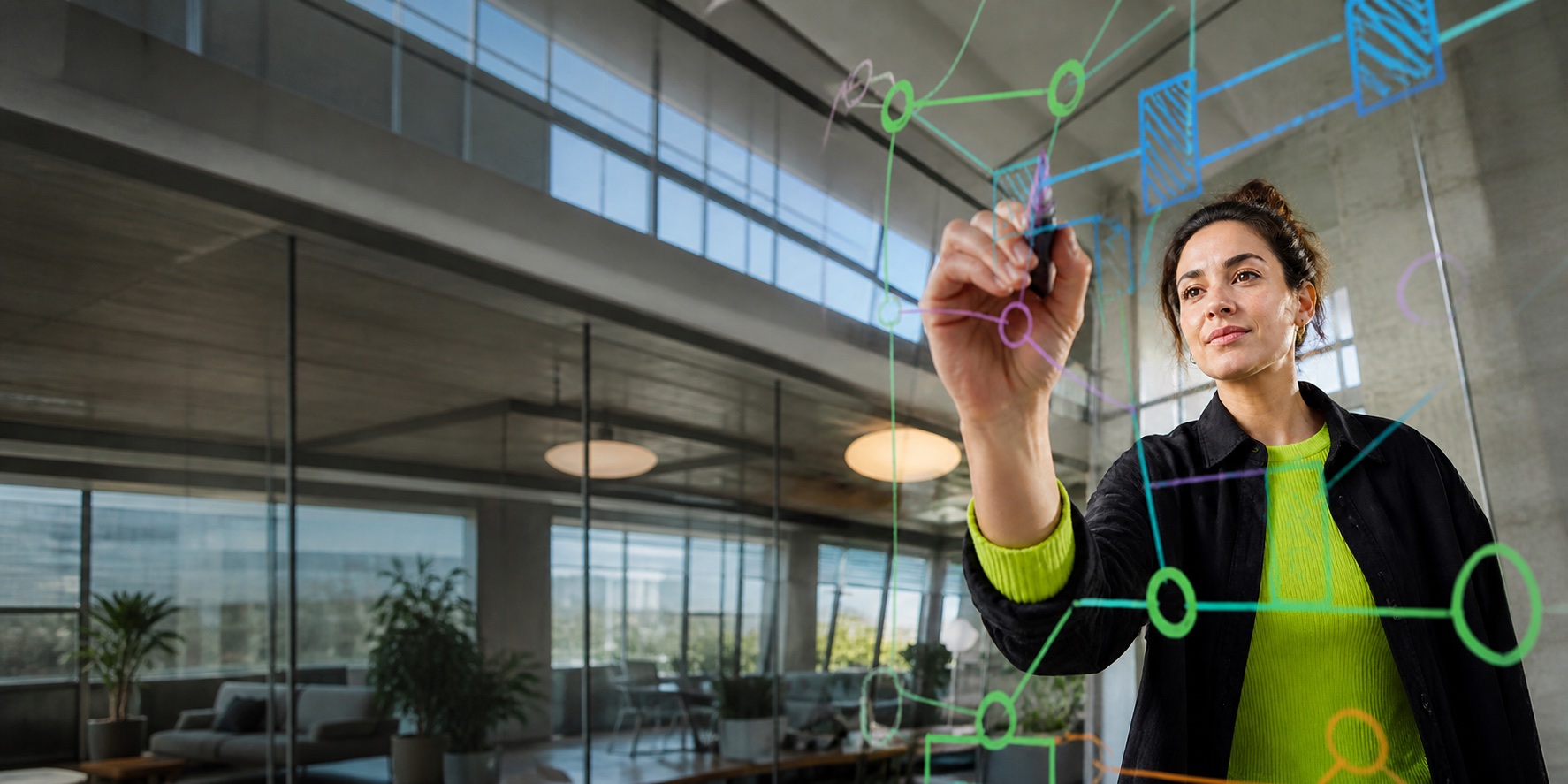 Engineer diagramming a connected system architecture on a glass board.