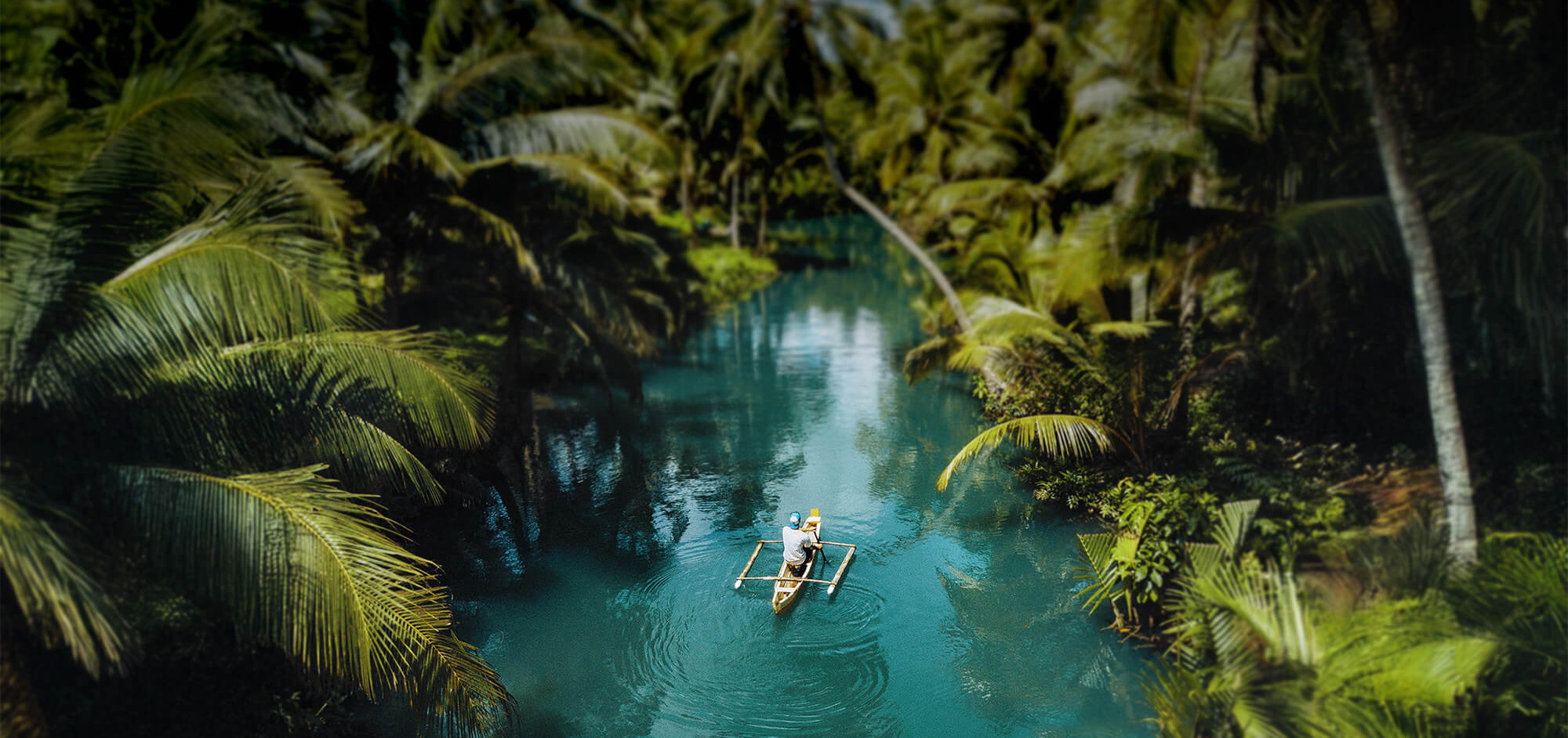 Traveler crossing a tropical river by canoe